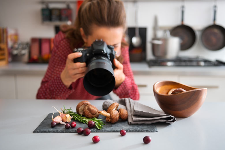 Une blogueuse travaille en cuisine avec un appareil photo